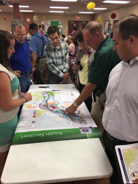 Participants at Tucson Public Scoping Meeting review an information board